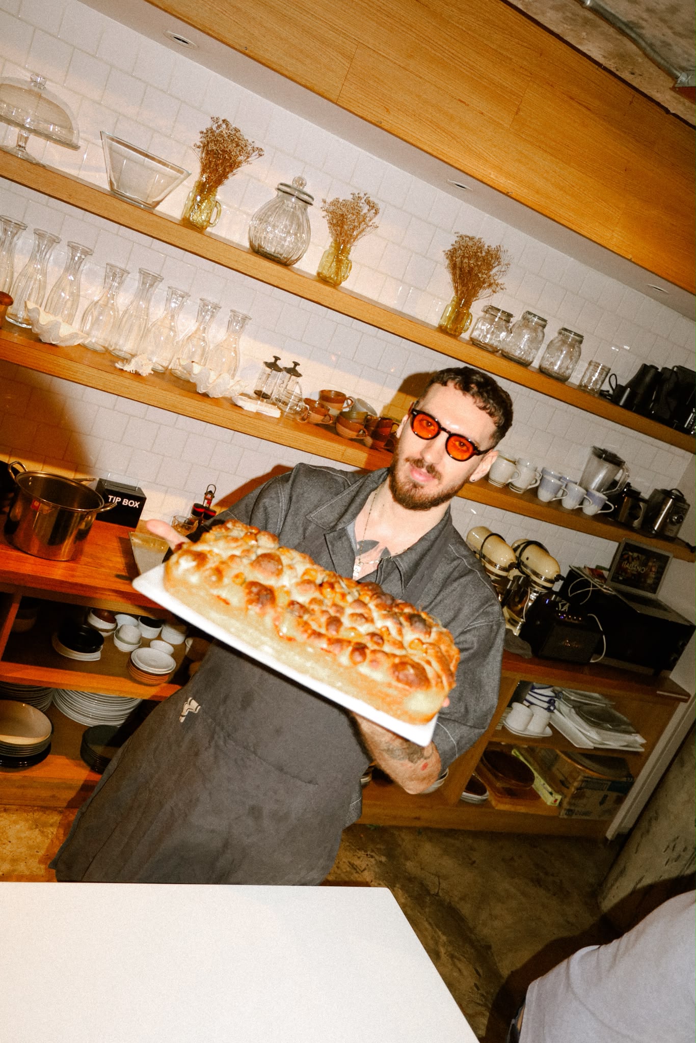Giuseppe Costanzo presenting freshly baked focaccia in the kitchen