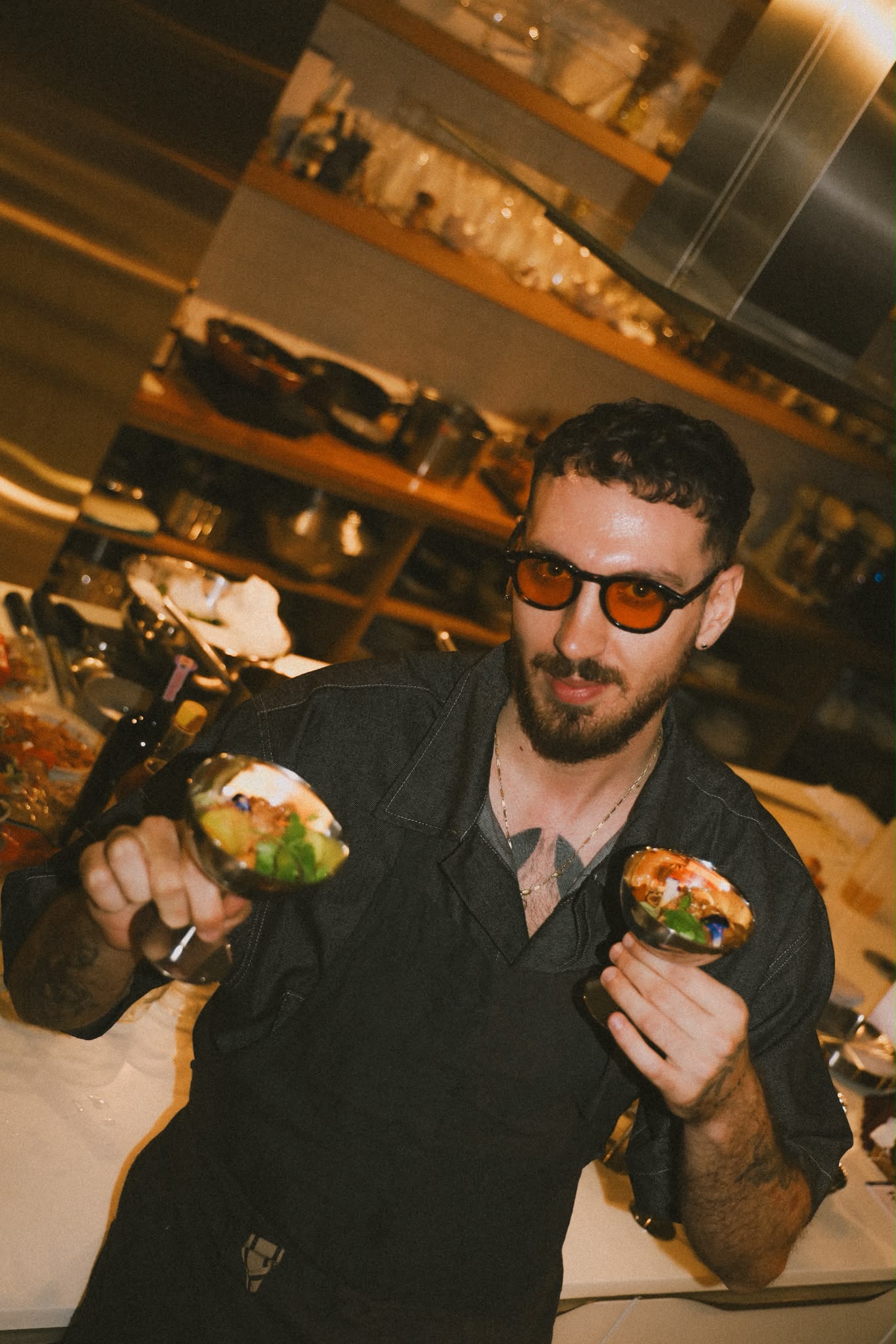 Giuseppe Costanzo holding two finished dishes during service